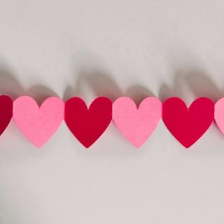 A row of connected pink and red paper hearts.