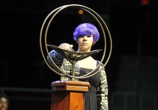 A young woman lights the Chalice at the 2014 UUA General Assembly.