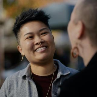 J. (they/them, Chinese American) and M. (they/them, White American), a nonbinary and interracial couple, expressing their love for each other on an outing in California.