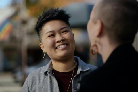 J. (they/them, Chinese American) and M. (they/them, White American), a nonbinary and interracial couple, expressing their love for each other on an outing in California.